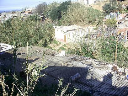 مخاطر الحجارة المتساقطة ومياه الوادي القذرة تهدد حياة السكان