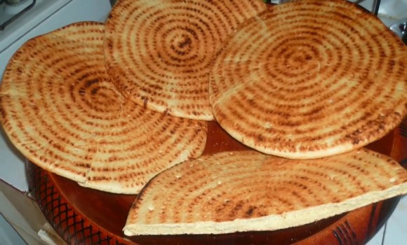 Préparation et cuisson de galettes traditionnelles dans les boulangeries: des Constantinoises défient la canicule