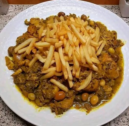Poulet en sauce avec frites et olives vertes