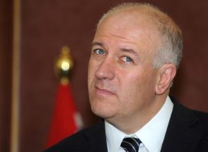 British Minister of State Bill Rammell listens to reporters'