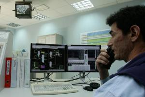 A technician talks on a walkie-talkie as he works