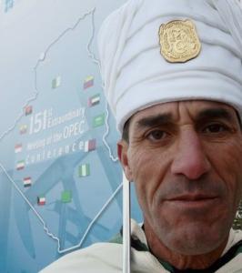 An honour guard stands next to an OPEC poster