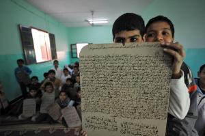 An Algerian student displays a slate with Qoran contents