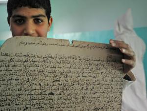 An Algerian student displays a slate with Qoran contents
