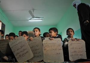 Algerian students recite Qoran contents on slates during a