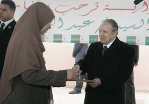 Algeria's President Abdelaziz Bouteflika gives a key to a