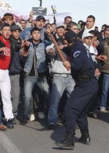 Protesters face a riot police officer Friday, Jan. 9,
