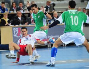 Poland's Kamil Kuchkzynski (L) is tackled by Algeria's Bouakaz