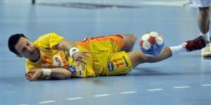 Macedonia's Vladimir Temelkov throws while lying on the pitch