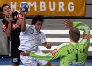 Algeria's Messaoud Berkous (C) scores past Germany's goalkeeper Johannes