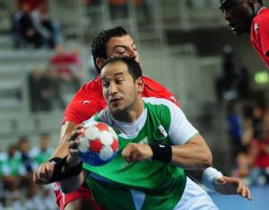 Algeria's Hichem Boudrali (C) vies for the ball with