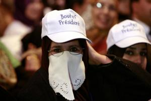 Supporters of Algerian President Abdelaziz Bouteflika listen to his