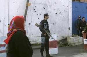 An Algerian woman walks past of the gate of