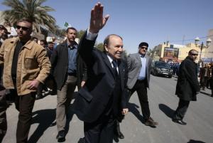 Algeria's President Abdelaziz Bouteflika (C) greets supporters while flanked by