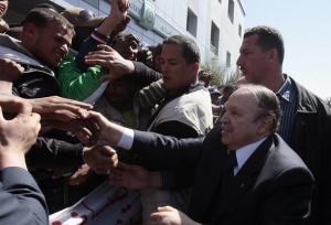 Algeria's President Abdelaziz Bouteflika (R) shakes hands with supporters as