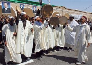 Residents, some holding portraits of Algerian President Abdelaziz Bouteflika, wait