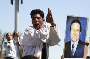 A supporter cheers for Algeria's President Abdelaziz Bouteflika (pictured on