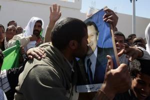 A supporter kisses a poster of Algeria's President Abdelaziz Bouteflika