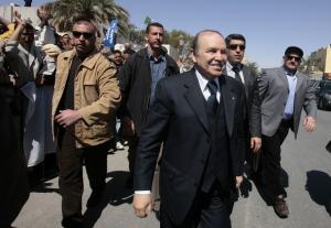Algeria's President Abdelaziz Bouteflika (C) walks while flanked by his