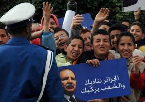 Algerian supporters carry posters of President Abdelaziz Bouteflika and shout
