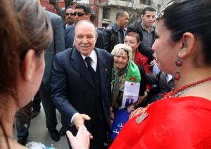 Algerian President Abdelaziz Bouteflika (C) shakes hands with supporters during