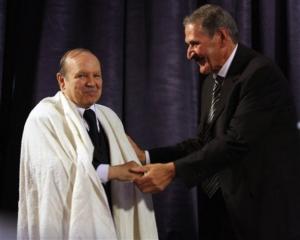 Algerian President Abdelaziz Bouteflika, left, receives a traditional  Burnous  robe