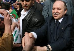 Algerian President Abdelaziz Bouteflika, right,  reacts with people in