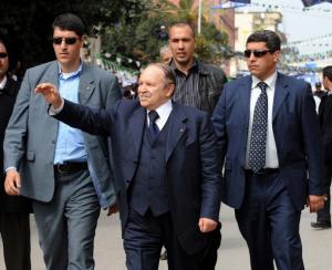 Algerian President Abdelaziz Bouteflika (C) waves to supporters during an