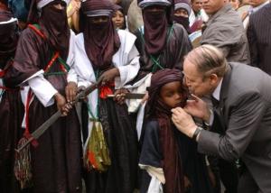 Algeria's President Abdelaziz Bouteflika, right, kisses a child as he