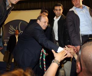 Algerian President Abdelaziz Bouteflika (C) shakes hands with supporters during