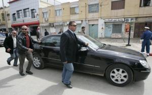 Bodyguards surround the car of Algeria's President Abdelaziz Bouteflika as