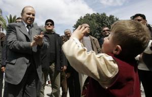 Algeria's President Abdelaziz Bouteflika dances with a child while campaigning