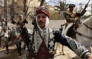 A horse rider dressed in traditional robes poses during the