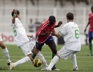 Gambia's Saihou Gassama (C) fights for the ball with Algeria's
