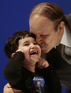 Algeria's President Abdelaziz Bouteflika kisses a child during his last