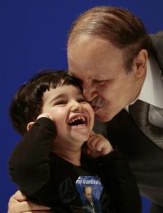 Algeria's President Abdelaziz Bouteflika kisses a child during his last