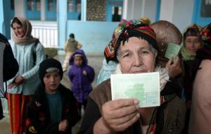 A Kabyle woman shows her voting Identification at a polling