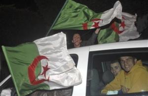 Young Algerians react waving Algeria's flags late Thursday April 9,