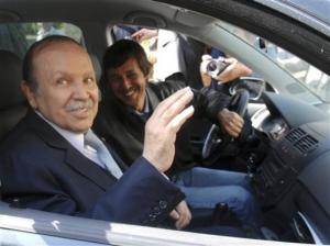 Algerian President Abdelaziz Bouteflika, foreground, waves as he arrives at