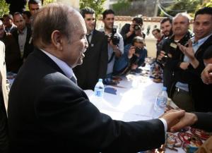 Algeria's President Abdelaziz Bouteflika shakes hands with journalists at his
