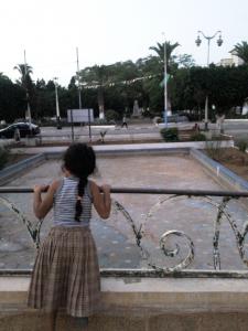 Une fillette sur le petit pont du jardin public