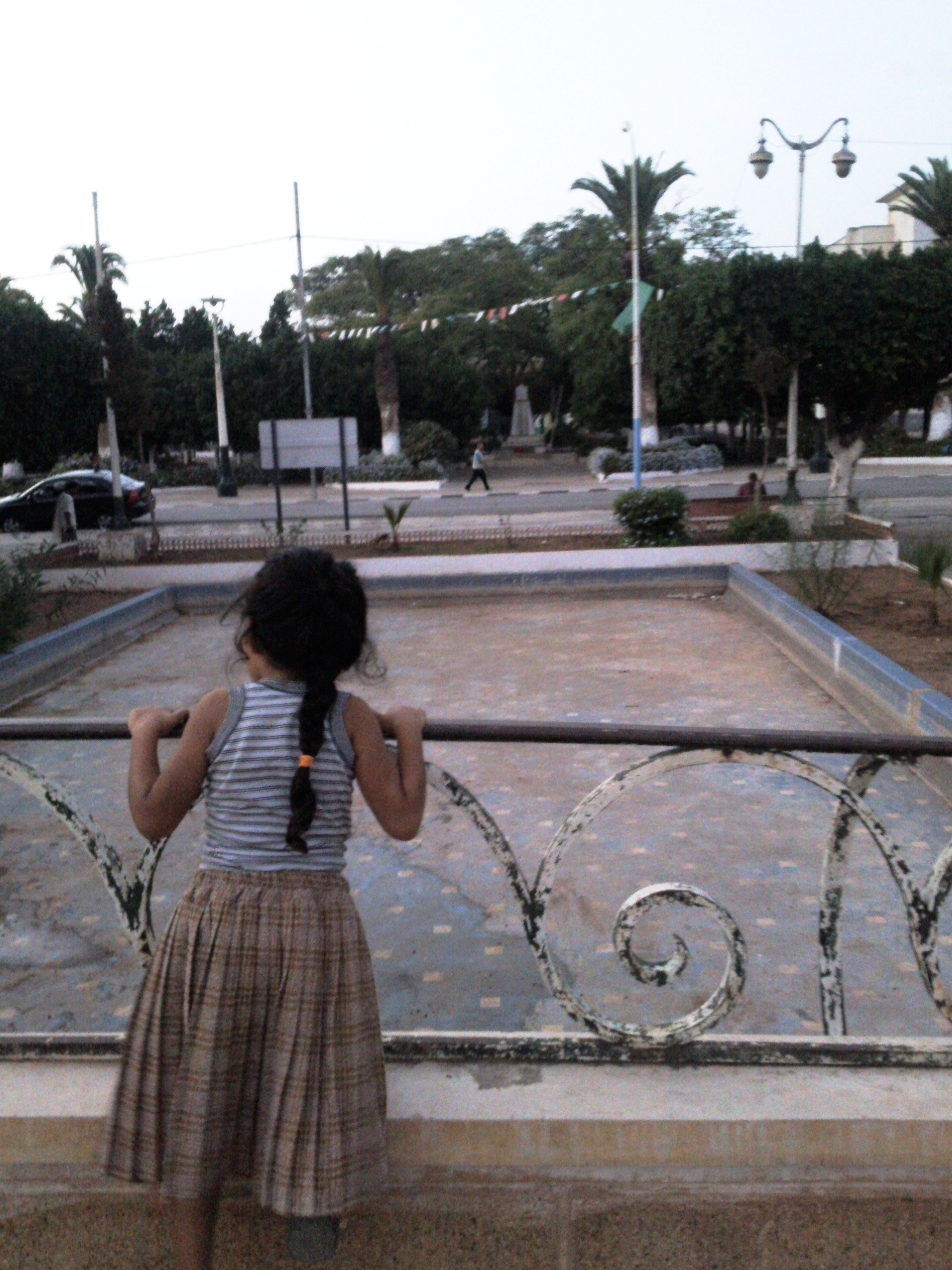 Une fillette sur le petit pont du jardin public