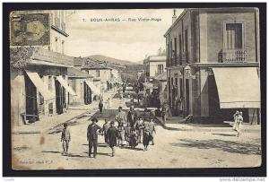 CPA  ANCIENNE- TUNISIE- SOUK-AHRAS  RUE VICTOR HUGO AVEC TRES BELLE ANIMATION GROS PLAN- COMMERCES