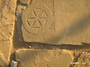 Motifs taillés sur pierre réutilisés comme dalles à Mansourah