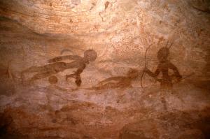 Djanet, Algérie. Partie droite de panneau peint. A droite, homme déplace vers la gauche avec deux plumes sur la tête,détient arc à double courbure dans une main et une flèche dans l\'autre main.