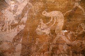 Oued Djaret, Algérie. Femme avec des virages de corps allongés gauche tenant possible d\'insectes et sac à mains tendues.