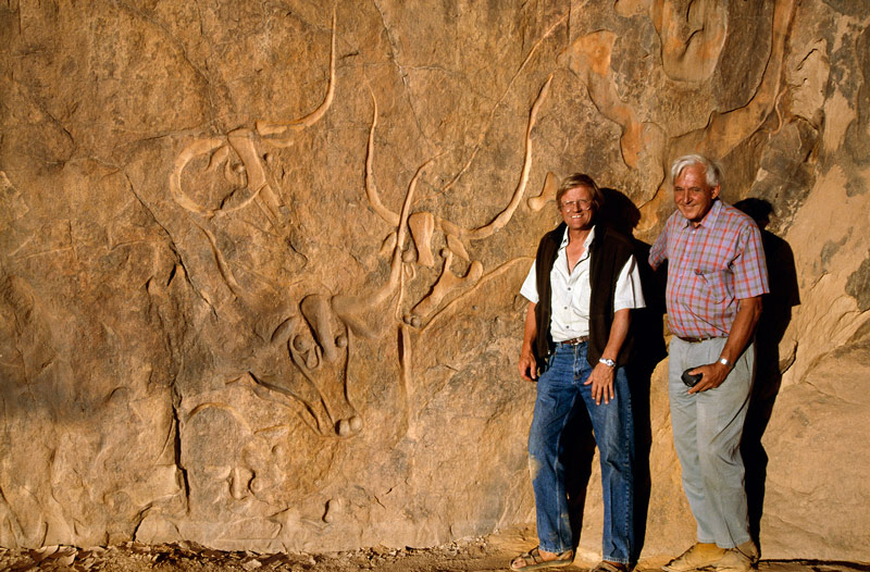 Djanet, Algérie. Affectation spéciale pour l'équipe d'enregistrement de African Rock Art, David Coulson (à gauche) et Alec Campbell debout debout à côté de gravures de bovins