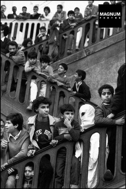 ALGÉRIE. Alger. 1981. La Casbah. Les jeunes hommes avec une femme en niqab, le voile traditionnel qui couvre son visage, ainsi que son corps.