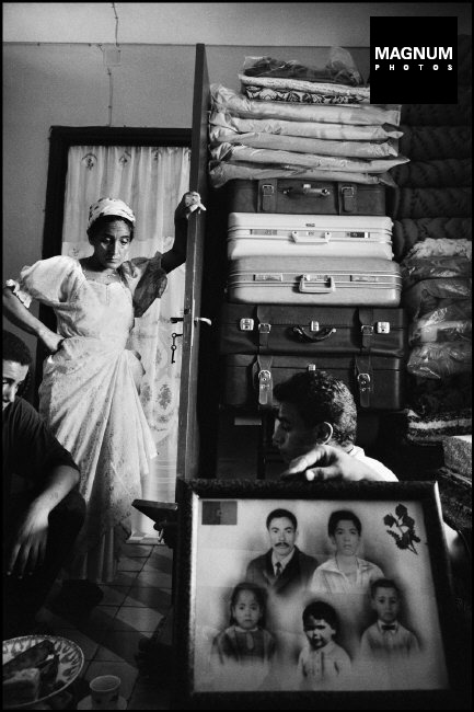 ALGÉRIE. Ville d'Oran. Les femmes derrière une photo de famille montrant son mari, qui a émigré en France dans les banlieues de Paris à Boissy-Saint-Léger.