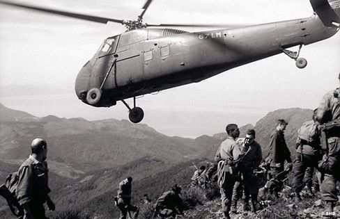 Un hélicoptère Sikorsky H-34 survole des soldats de l'armée de l'air, durant une patrouille dans le Djebel Chélial, le 12mars 1961.